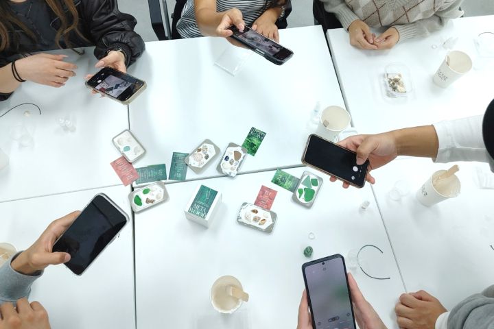 [사진2] 워크숍 참가 학생들이 완성된 업사이클링 오브제 방향제와 해양 소재 작품들을 테이블에 모아두고 스마트폰으로 촬영하며 인스타그램 SNS 인증 및 소감을 공유하고 있다. (사진제공=한동대)