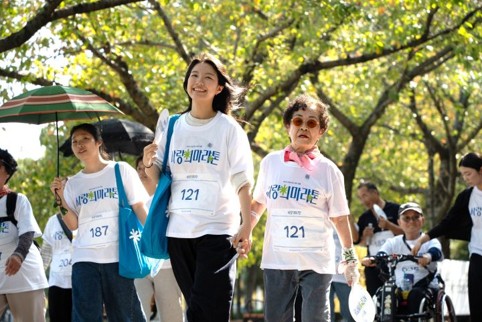 [사진2] 같은 번호표를 단 한동대 재학생 스텝과 참가자가 손을 맞잡고 제18회 '사랑의 마라톤' 코스를 함께 걷고 있다.