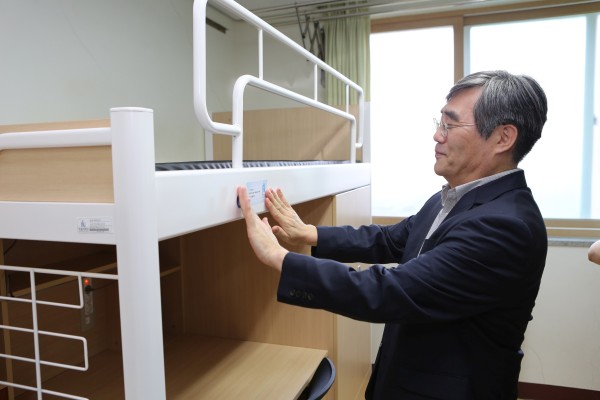 (사진5)이광인 학부모기도회 회장이 학부모 후원자의 이름이 새겨진 스티커를 새 가구에 붙이고 있다.